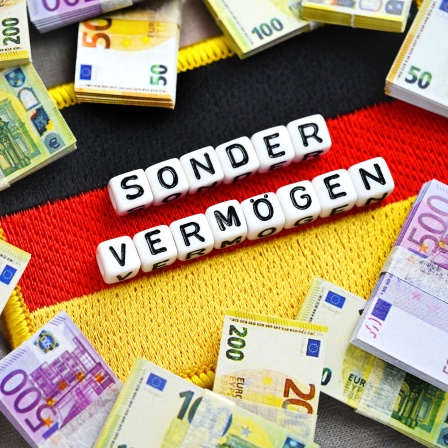 Deutschlandfahne mit Aufschrift Sondervermögen und Geldscheinen.