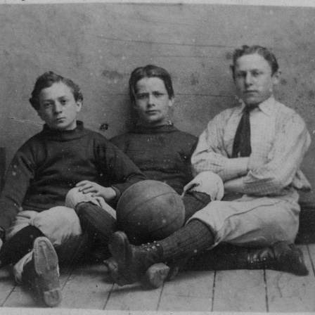 Drei Jungs in Sportkleidung mit Fußball, England um 1885