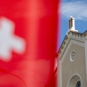 Im Hintergrund eine Synagoge, im Vordergrund die Schweizer Flagge.