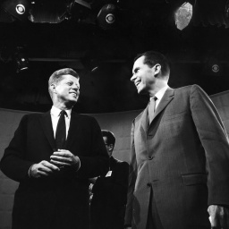 Historisches Schwarzweißfoto von John F. Kennedy und Richard Nixon, die im TV-Studio nebeneinander stehen.