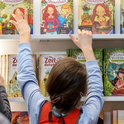 Ein Kind greift 2018 nach Kinderbüchern an einem Stand auf der Leipziger Buchmesse.