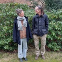 Lisa Kreißler und Joachim Dicks stehen vor einem Rhododendron und schauen sich an. 