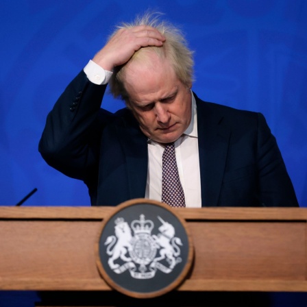 Boris Johnson, Premierminister von Großbritannien, fasst sich mit einer Hand durch die Haare.