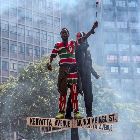 Ein Demonstrant auf einem Straßenschild in der kenianischen Hauptstadt Nairobi