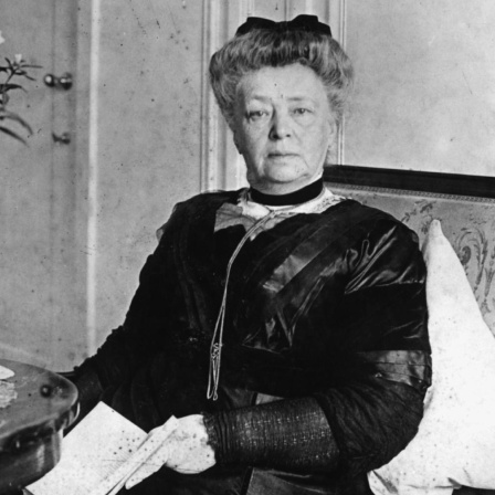 Bertha von Suttner in einer Fotoaufnahme: Sie sitzt auf einem Foto und blickt in die Kamera