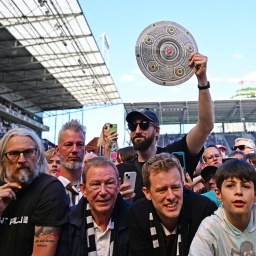 Ein Fan des FC St. Pauli hält beim Bundesliga-Aufstieg eine Meisterschale in die Höhe.