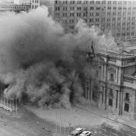 Historisches Schwarzweißfoto vom Präsidentenpalast in Santiago de Chile, aus dem Rauch aufsteigt.