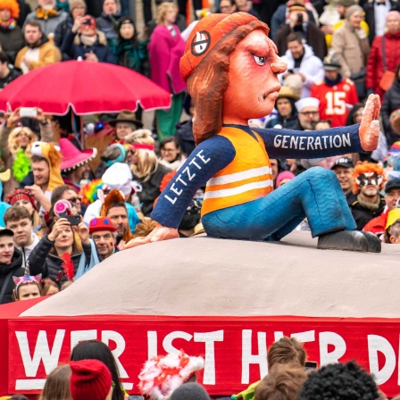 Motivwagen im Düsseldorfer Karneval von Wagenbauer Jacques Tilly: Klimaaktivisten der Letzten Generation blockieren einen qualmenden LKW