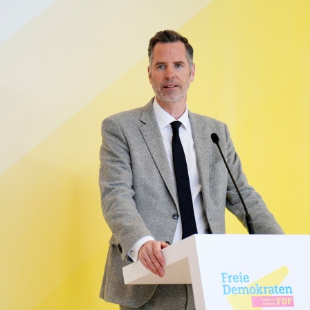 Christian Dürr (FDP) spricht bei einem Pressestatement seiner Fraktion vor einem gelben Hintergrund.