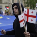 Demonstrant mit georgischen Flaggen und EU-Fahne. 