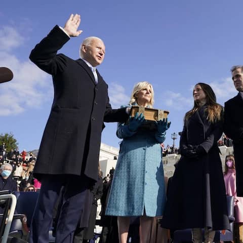 Joe Biden wird mit Hand auf der Bibel als 46. Präsident der USA vereidigt. Im Hintergrund ist das Capitol zu sehen.