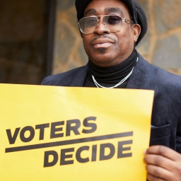 ein Wähler hält ein  gelbes Plakat hoch in Milwaukee, Wisconsin, USA 