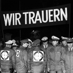 Mit einem schwarzen Transparent und der Aufschrift &#034;Wir trauern&#034; demonstrieren Polizisten während eines Trauermarsches durch die Frankfurter Innenstadt am 4. November 1987. Sie zeigen ihre Bestürzung über den Tod der am 2. November während einer Demonstration an der Startbahn West des Frankfurter Flughafens erschossenen zwei Kollegen.