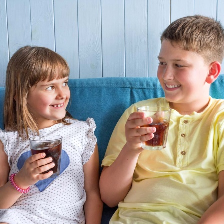 Zwei Kinder trinken ein zuckerhaltiges Getränk (Bild: IMAGO / Pond5 Images)
