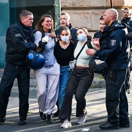 Die pro-palästinensischen Besetzer des Instituts für Sozialwissenschaften der Berliner Humboldt-Universität (HU) verlassen mit Polizeibegleitung das Gebäude. 