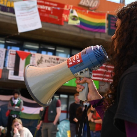 Die Veranstaltungsleiterin liest Auflagen der Polizei vor, während propalästinensische Aktivisten in einem Gebäude der Universität Bremen ein Protestcamp errichtet haben. Rund 25 bis 30 Menschen seien zu einer unangemeldeten Kundgebung zusammengekommen, sagte ein Polizeisprecher am Mittwoch.