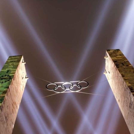 ARCHIV - Die Olympischen Ringe über dem Eingang werden am 16.12.2005 im Olympiastadion in Berlin mit Scheinwerfern angestrahlt (Bild: picture alliance/dpa/Soeren Stache)