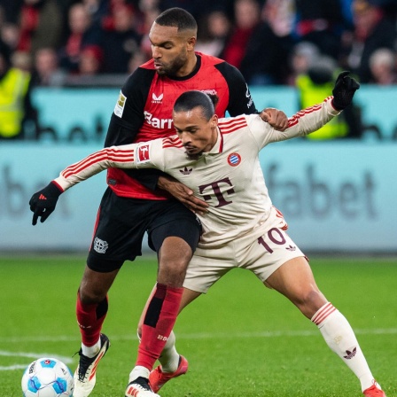 Leverkusens Jonathan Tah und Bayerns Leroy Sane kämpfen um den Ball