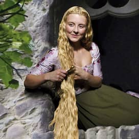 Rapunzel (Luisa Wietzorek) sitzt im Fenster ihres Turms und kämmt ihr blondes Haar (Quelle: rbb/Arnim Thomaß/Isabella Malek)