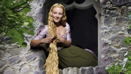 Rapunzel (Luisa Wietzorek) sitzt im Fenster ihres Turms und kämmt ihr blondes Haar (Quelle: rbb/Arnim Thomaß/Isabella Malek)