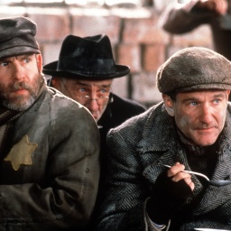 Das undatierte Archivbild zeigt den Juden Jakob Heym (Robin Williams, r.), der in dem neuen Kinofilm "Jakob der Lügner" 1944 im Warschauer Ghetto mit dem Arzt Dr. Kirschbaum (Armin Mueller-Stahl, M.) und anderen Leidensgenossen eine karge Mahlzeit einnimmt (Szenenfoto).