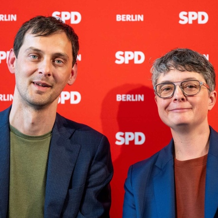 Martin Hikel und Nicola Böcker-Gianinni nach ihrer Wahl zum neuen SPD-Führungsduo in Berlin vor einer SPD Berlin Leinwand.