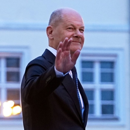 Der geschäftsführende Bundeskanzler Olaf Scholz (SPD) verlässt nach der Übergabe der Entlassungsurkunden durch Bundespräsident Steinmeier winkend das Schloss Bellevue.