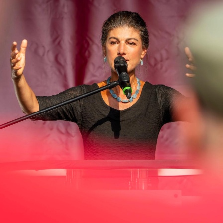 Sahra Wagenknecht spricht bei einem Wahlkampfauftritt mit gehobener Hand in Altenburg in ein Mikrofon.