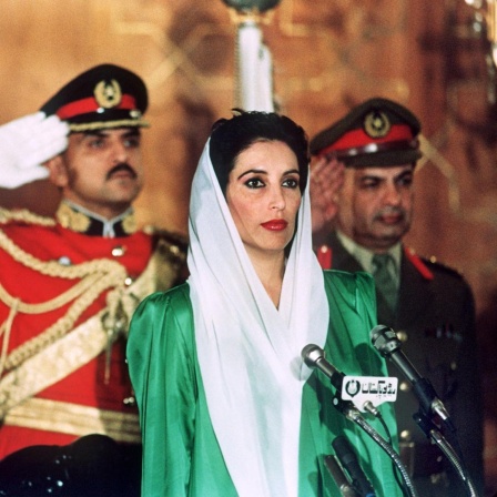 Benazir Bhutto während ihrer Vereidigung in Islamabad neben Präsident Ghulam Ishaq Khan. Die Pakistanische Volkspartei (PPP) unter Führung der 35jährigen Politikerin ist aus den Parlamentswahlen am 16. November 1988 als klarer Sieger hervorgegangen. Am 1. Dezember wird Benazir Bhutto zur ersten Ministerpräsidentin eines islamischen Staates ernannt.