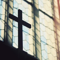 Kreuz vor einem Kirchenfenster