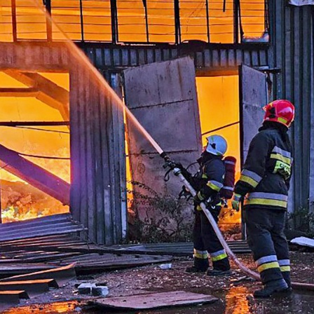 Zwei Rettungskräfte löschen ein Feuer nach einem Drohnenangriff auf die Stadt Lemberg (Lwiw, Ukraine).