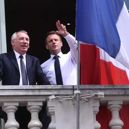 Der französische Präsident Emmanuel Macron (r) unterhält sich mit dem französischen Vorsitzenden der Modem-Partei und Bürgermeister von Pau, Francois Bayrou, dem Balkon des Rathauses während eines Besuchs in Pau (Archivbild). 