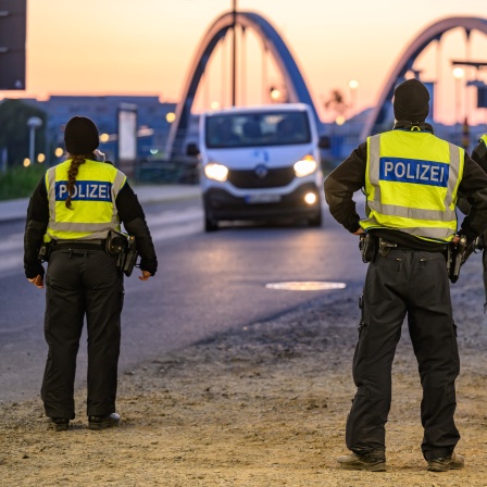 Beamte der Bundespolizei stehen am frühen Morgen bei der Einreisekontrolle am deutsch-polnischen Grenzübergang Stadtbrücke. Die Bundespolizei hat die Kontrollen an den Grenzen verschärft.