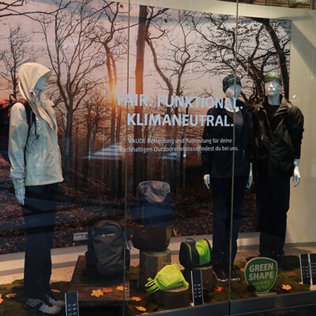 27.09.2023, Deutschland, NRW, Fashion, Outdoor Bekleidung, Ein Schaufenster mit Outdoor Artikeln des Herstellers VAUDE, Schriftzug Fair - Funktional - Klimaneutral, Outdoorjacke, Wandern, Bergsport, Bekleidungsproduzent, Umweltaspekt, umweltfreundlich, nachhaltig