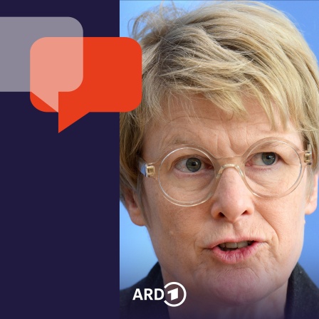 Wirtschaftswissenschaftlerin Veronika Grimm sitzt vor dem blauen Hintergrund der Bundespressekonferenz.
