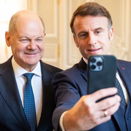 Bundeskanzler Olaf Scholz (links) und der Präsident von Frankreich, Emmanuel Macron (rechts), machen im Elysee-Palast ein Selfie.