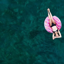 Eine Frau treibt auf einem aufblasbaren Schwimmring im Meer.