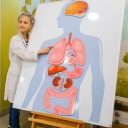 Zwei Mädchen stehen vor einem Plakat mit menschlichen Organen.