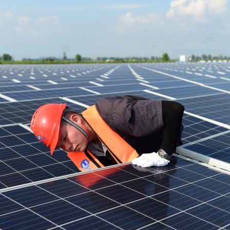 Ein Angestellter arbeitet an Solarpaneelen auf einem schwimmenden Solarzellen-Park in der ostchinesischen Provinz Anhui. Chinesische Behörden investierten circa 131 Millionen Euro (1 Milliarde Yuan) in einen schwimmenden 150-Megawatt-Solarpark, der Energiegewinnung und Fischerei kombinieren soll.