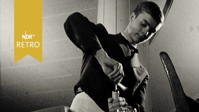 Junger Kellner beim Entkorken einer Weinflasche (1965, Aufnahme von unten)