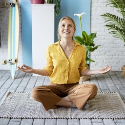 Young woman meditating while sitting on mat at home model released Symbolfoto property released RCPF01054 bei imago geladen 22.06.2021