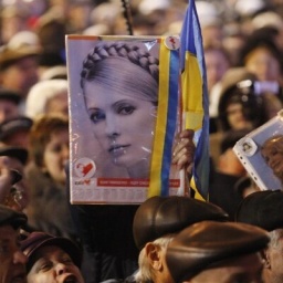 Ein Demonstrant hält ein Plakat mit einem Bild der ehemaligen Premierministerin Julia Timoschenko während einer Kundgebung auf dem zentralen Platz in Kiew anlässlich des 7. Jahrestages der Orangenen Revolution von 2004 hoch.