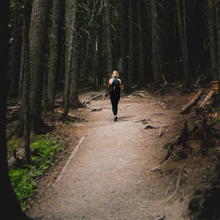 Eine Person läuft auf einem Waldweg