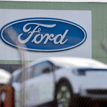 Außenansicht eines Gebäudes der Fordwerke in Köln. An der Wand ist das Firmenlogo angebracht.