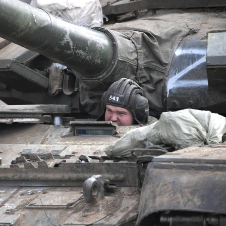 Der Kopf eines Soldaten sieht aus einem Panzer