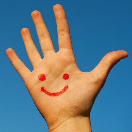 Eine Handfläche mit einem gezeichneten Smiley