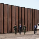Joe Biden (M), Präsident der USA, besucht die Grenze zwischen den USA und Mexiko und geht mit US-Grenzschutzbeamten entlang eines Abschnitts am Grenzzaun in El Paso, Texas.