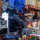 Polizisten führen in einem Eiscafé in der Duisburger Innenstadt eine Razzia durch
