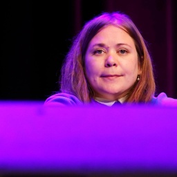 Eine junge Frau mit schulterlangen rötlich-hellbraunen Haaren sitzt auf einem Podium. Es ist die österreichische Autorin Stefanie Sargnagel.