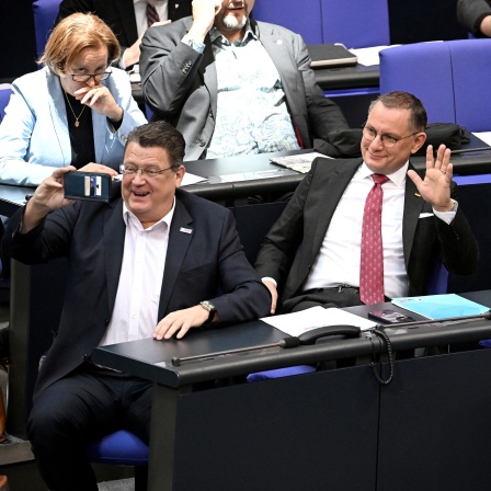 Tino Chrupalla (M-l) und Alice Weidel von der AfD grüßen in die Camera von Stephan Brandner (l) in der 214. Plenarsitzung der 20. Legislaturperiode im Deutschen Bundestag. 